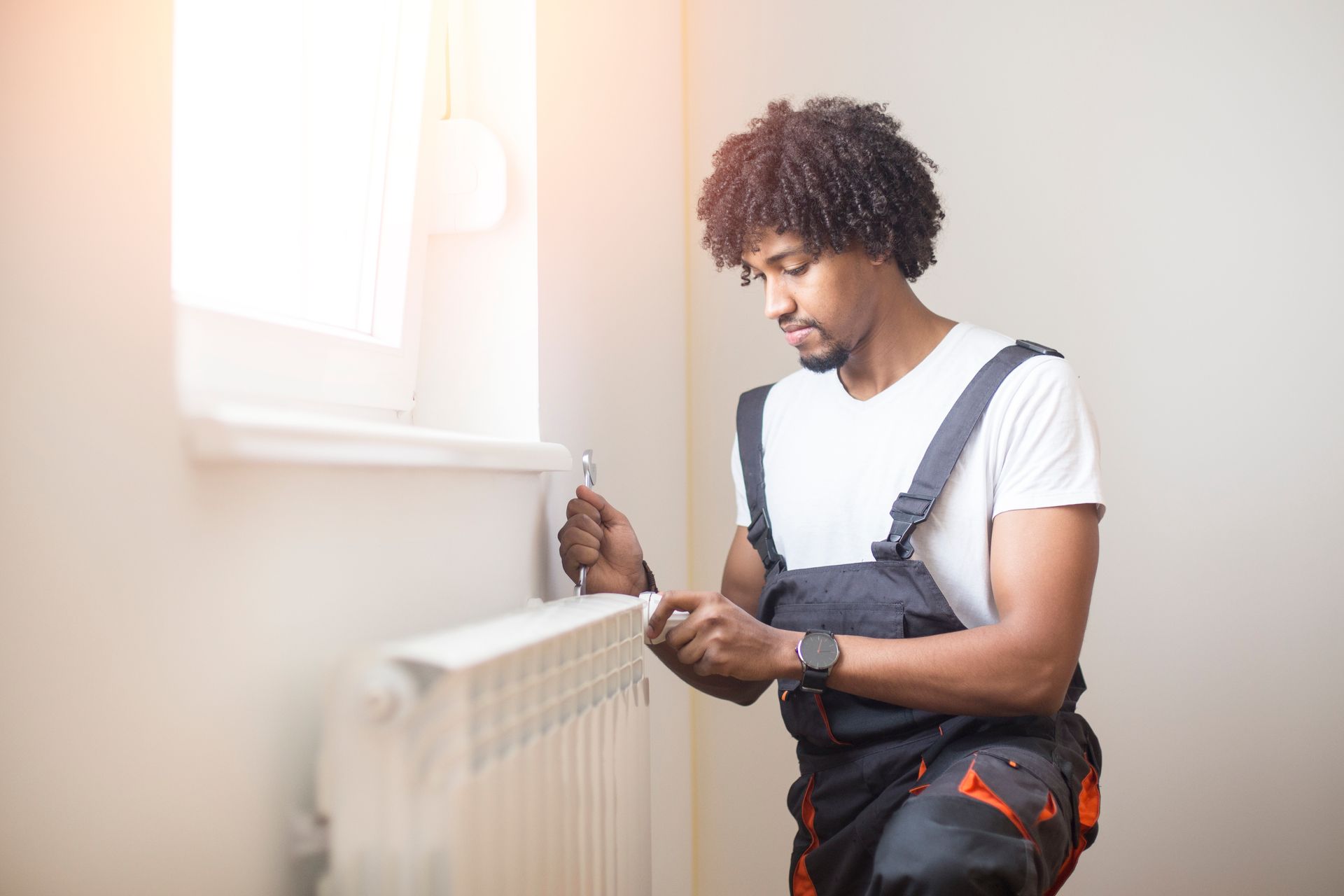 A young man from Witkowski Mechanical is performing a heating maintenance at a client’s home in Timonium, MD.