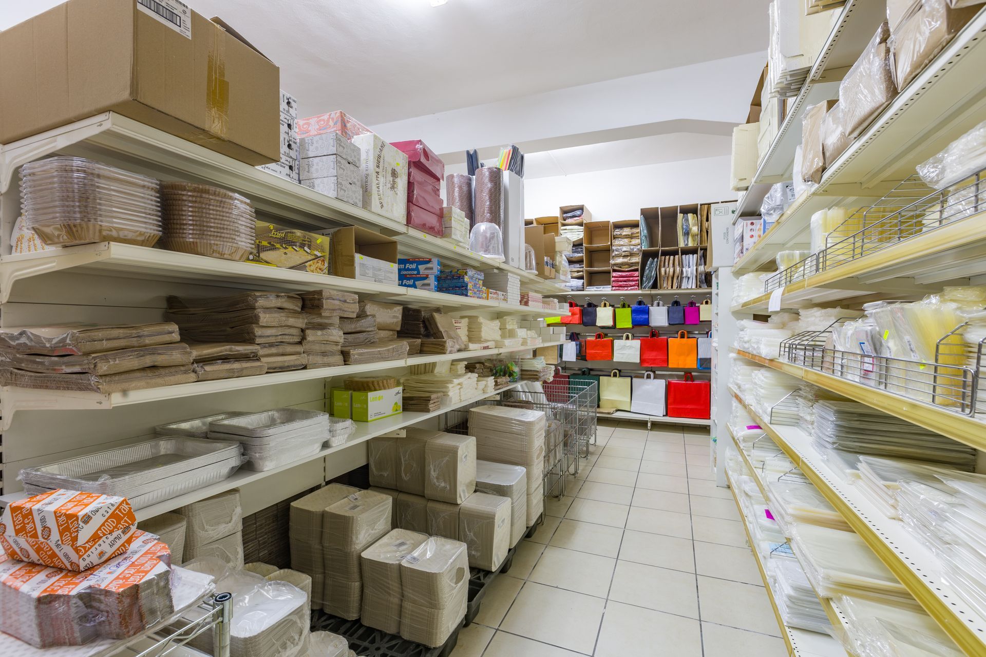 Scatole e bicchieri marroni in imballaggi sostenibili, con piante disposte su un tavolo beige