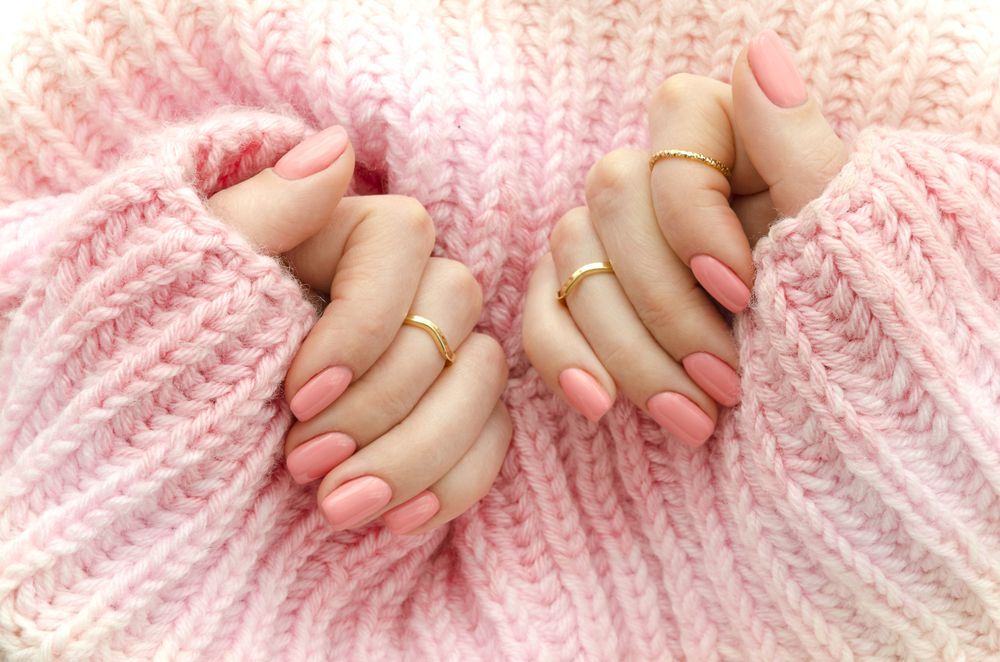 a woman wearing pink nails