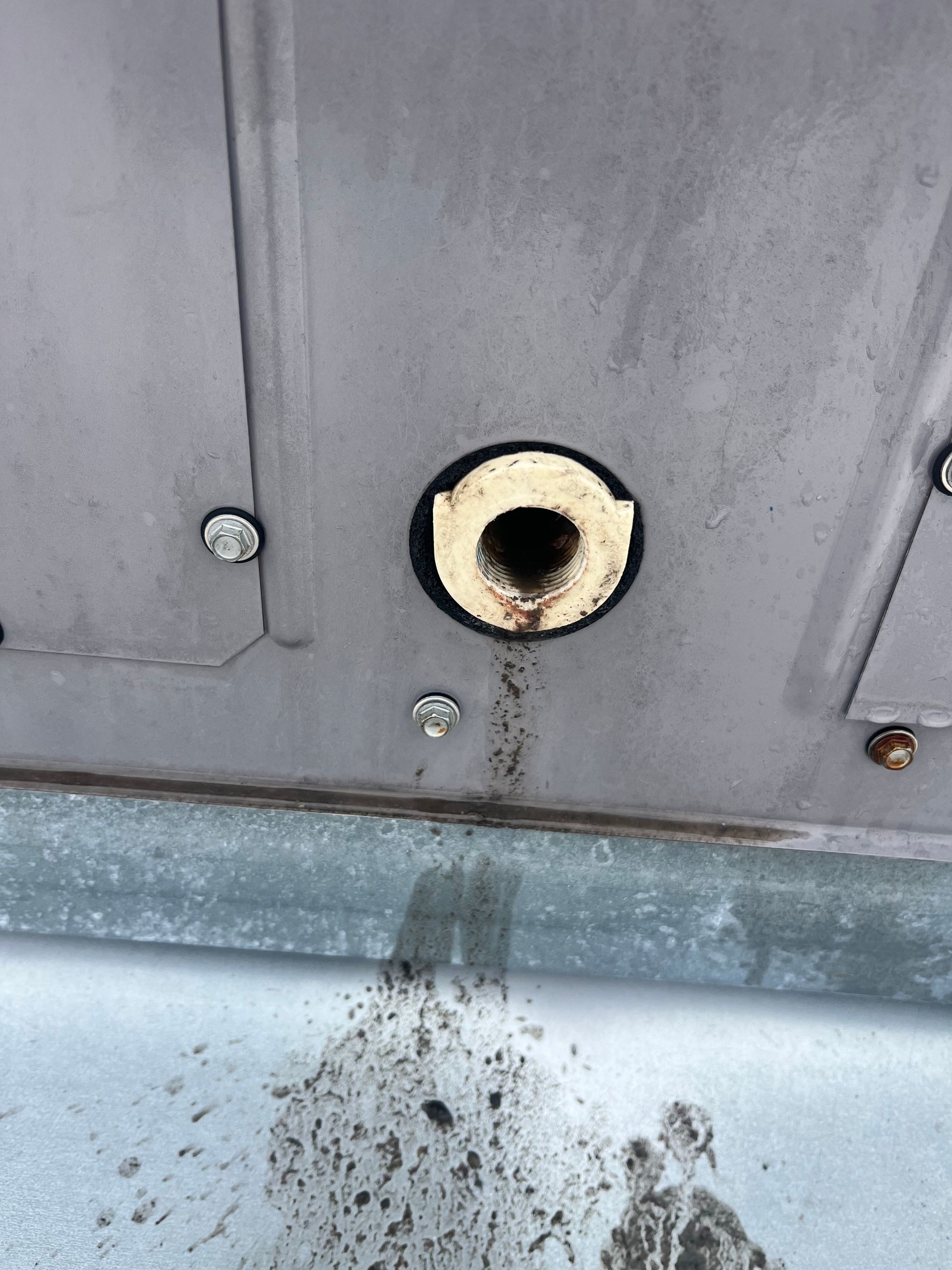 Person attaching gauges to an outdoor air conditioning unit.