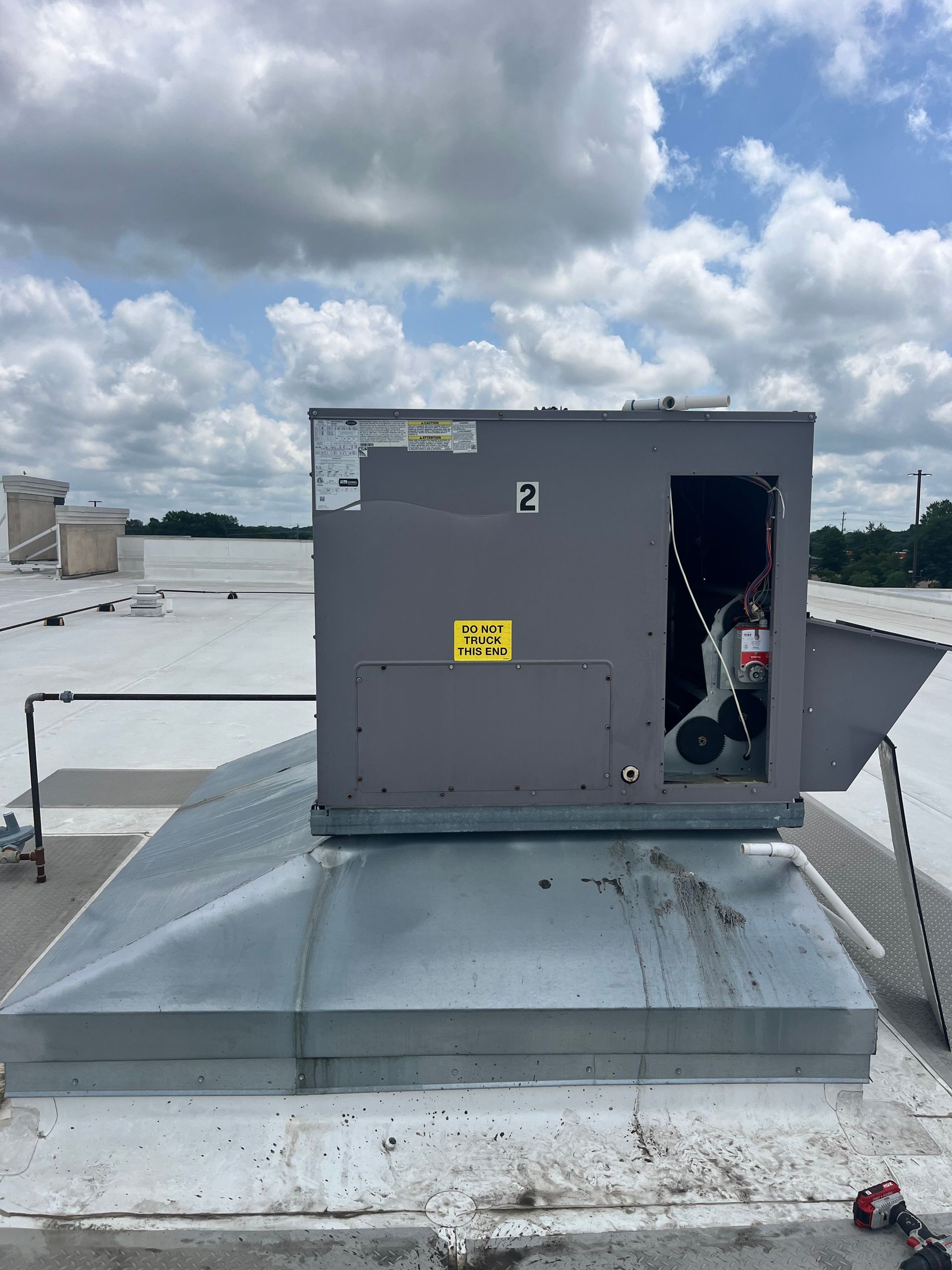Person attaching gauges to an outdoor air conditioning unit.