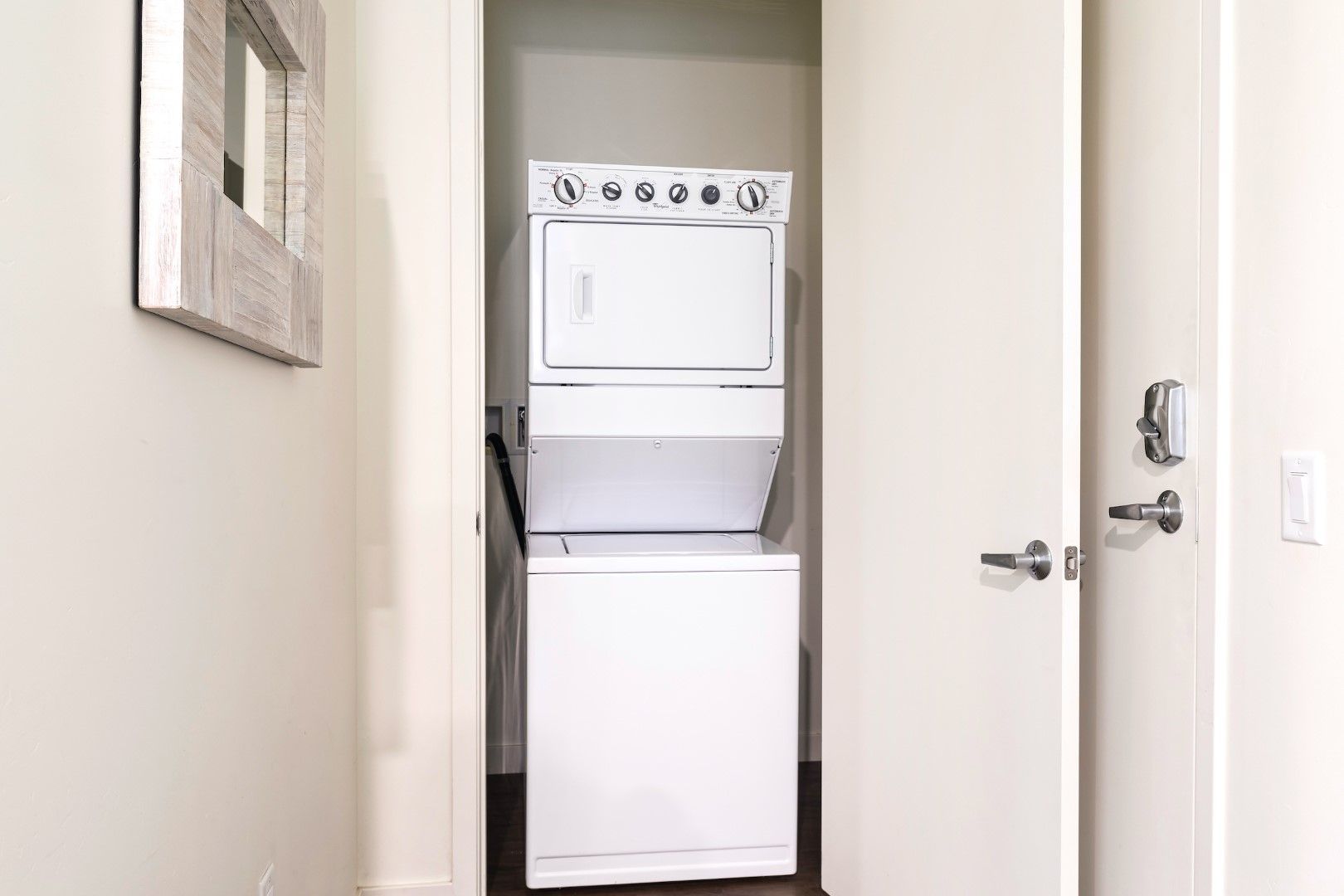 A washer and dryer are stacked on top of each other in a closet.