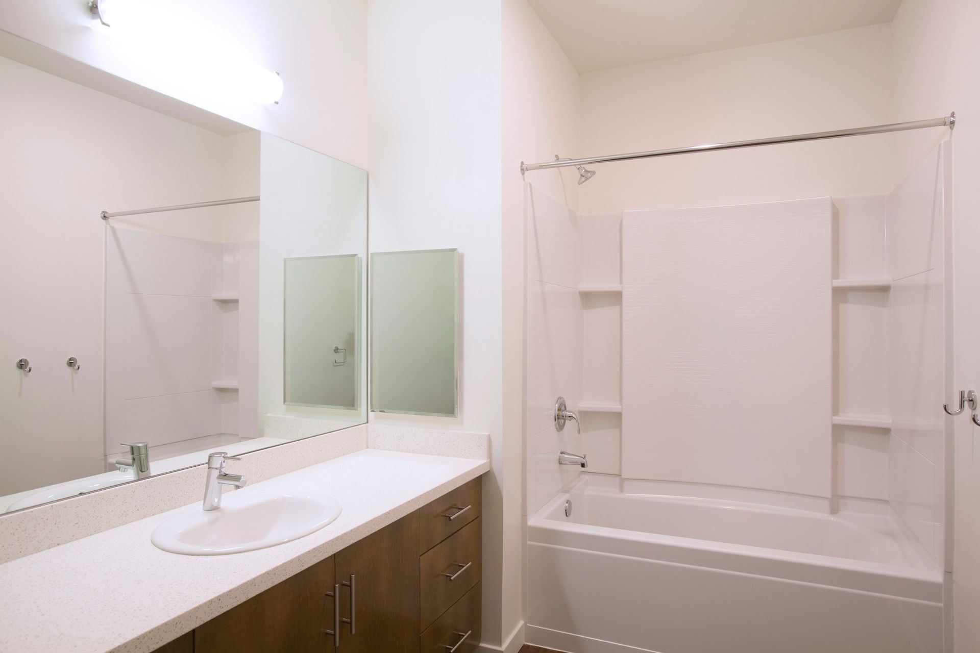 A bathroom with a sink , tub , shower and mirror.