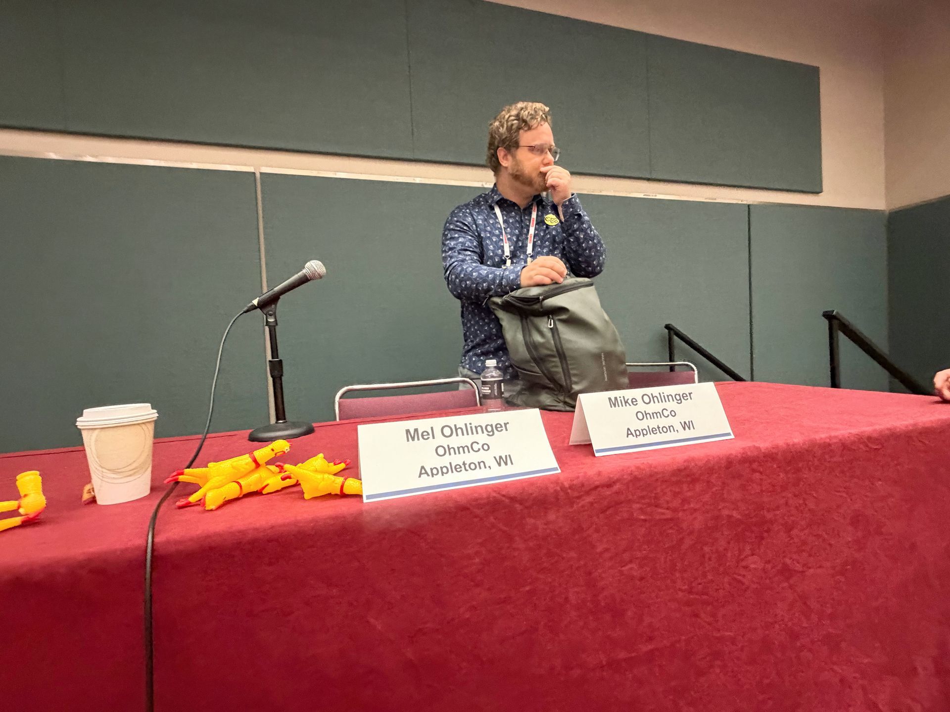 Speaker table with Mel and Mike Ohlinger name cards and rubber chickens on a red tablecloth