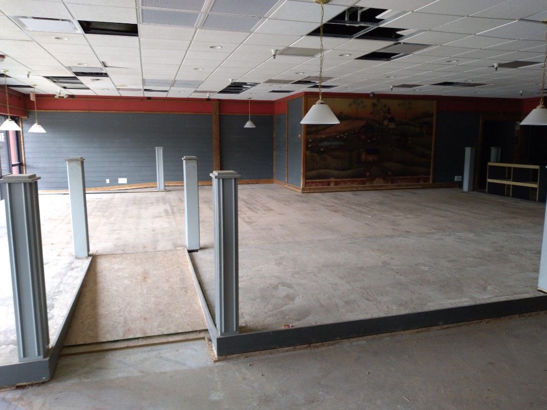 A large empty room with a painting on the wall