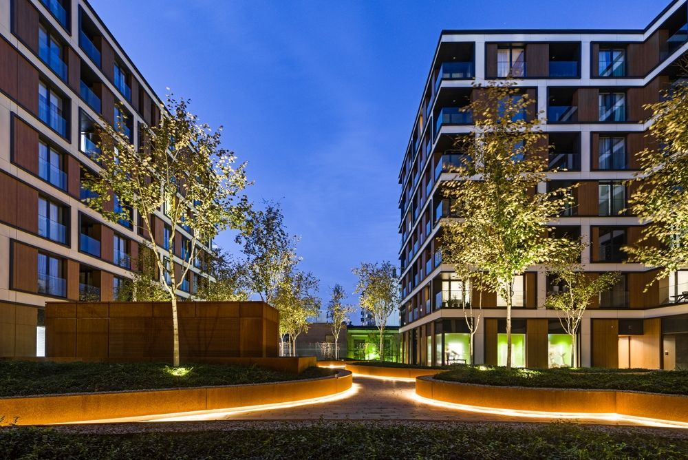 A row of buildings with trees in front of them at night