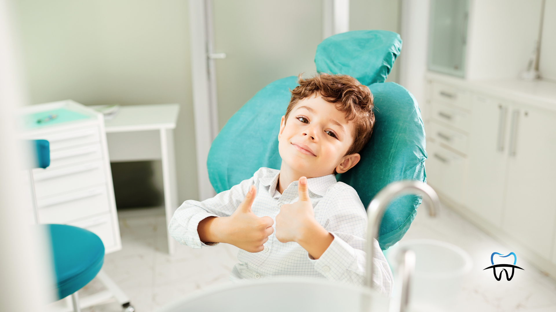 Boy in a dentist chair giving thumbs-up. Blue chair, white office setting.