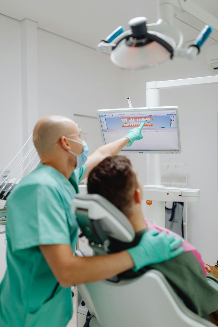 Woman at dentist's, mouth open, examined with mirror. Blue dental cloth, gloves.