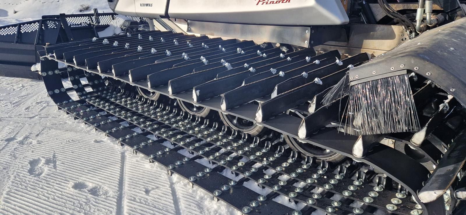 A close up of a snowmobile 's tracks in the snow.