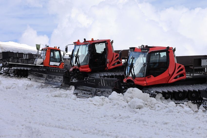 Close-up of a red snow grooming drag, showing the intricate design used for smoothing snow on ski trails.