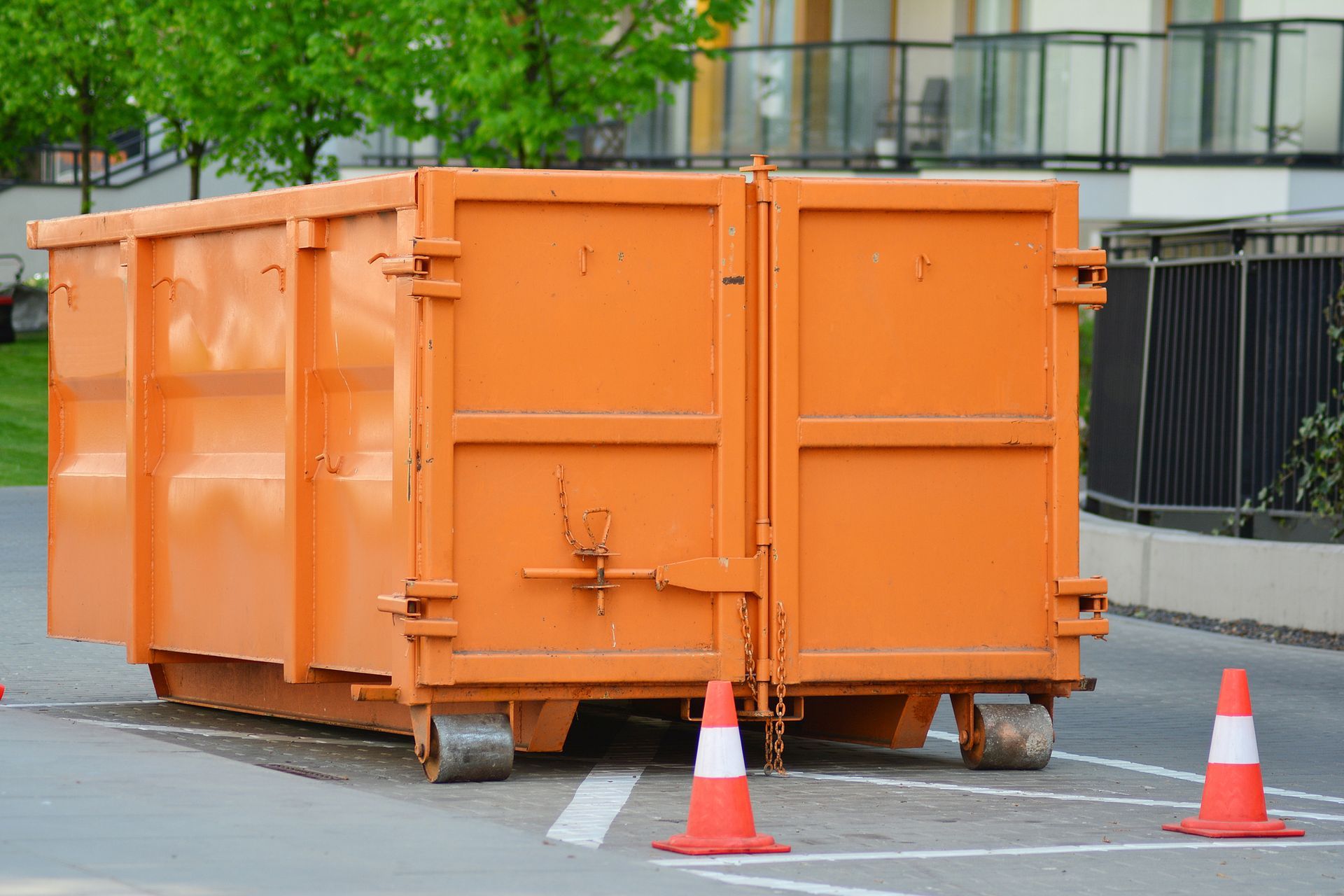 Orange roll off dumpster rental bin outdoors for construction debris and waste removal services. Orange roll off dumpster rental bin outdoors for construction debris and waste removal services.