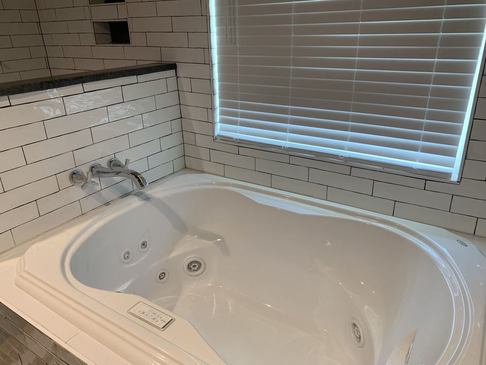 a bathroom with a jacuzzi tub and a window .