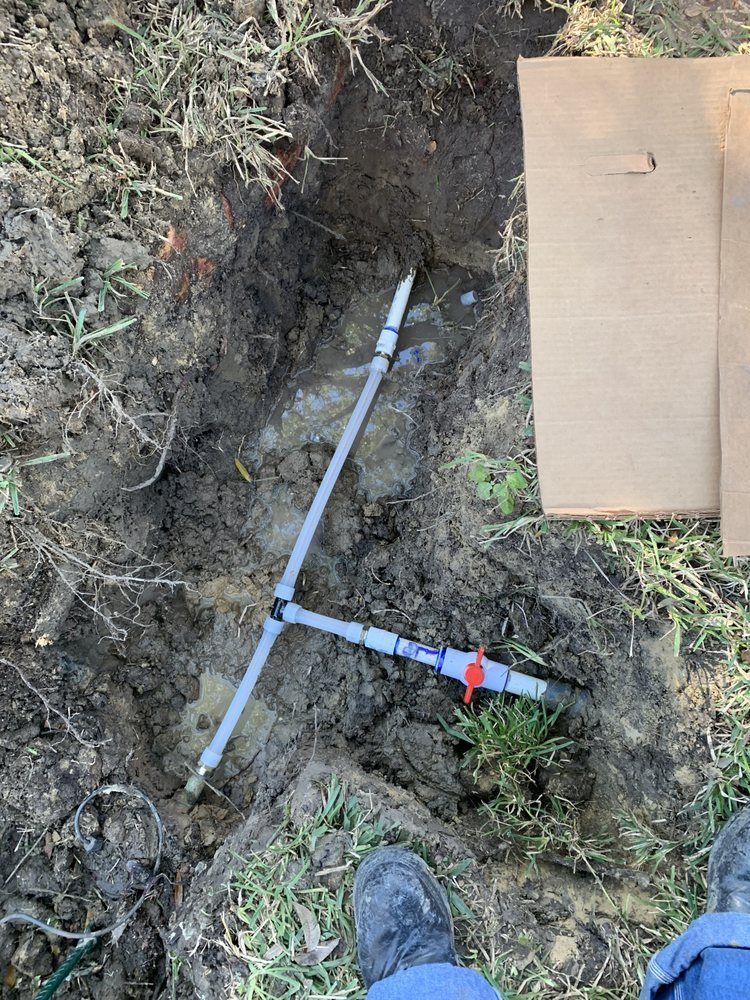 a person is standing next to a pipe in the dirt .