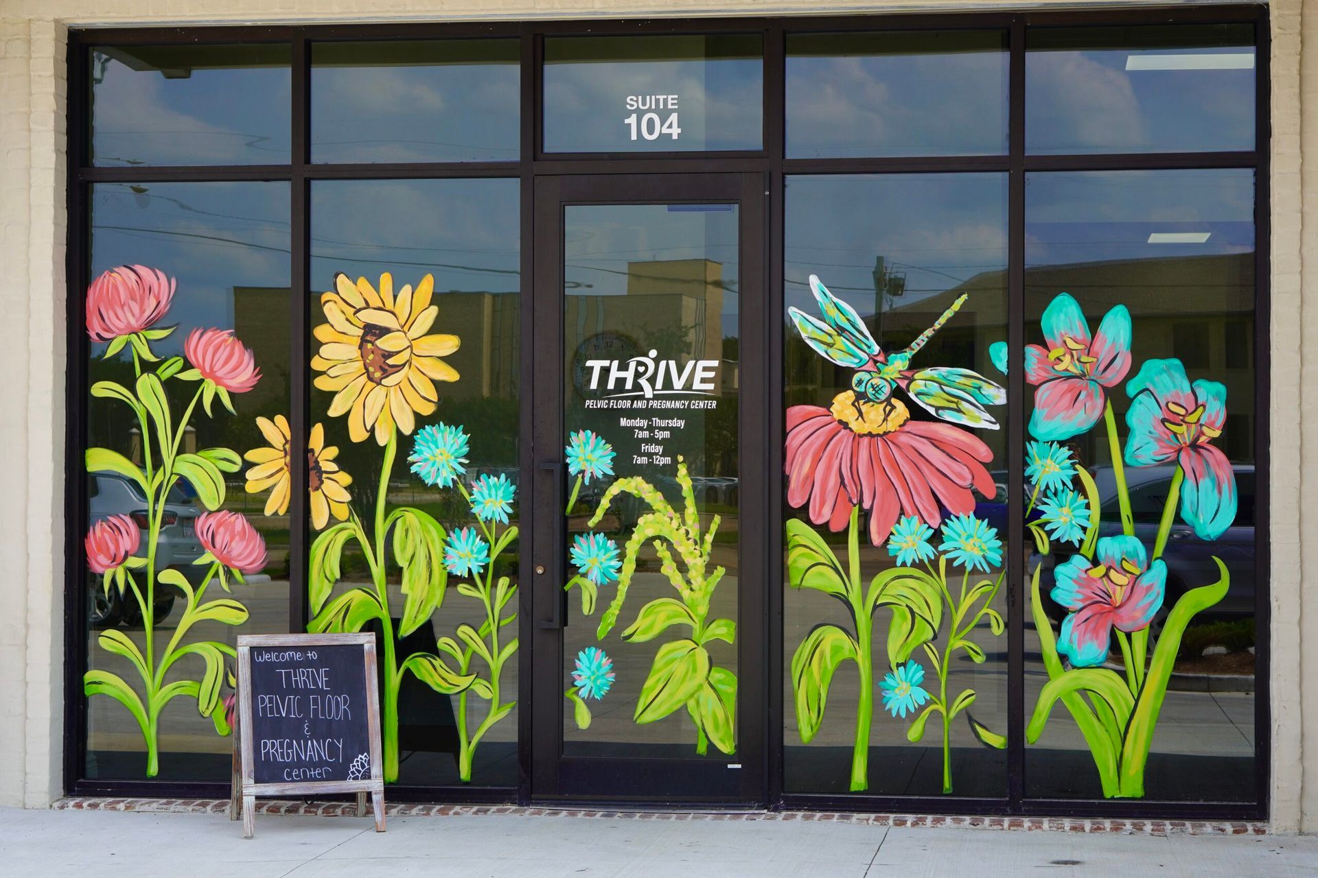 Storefront with bright floral window mural and a “THRIVE” sign above the entrance