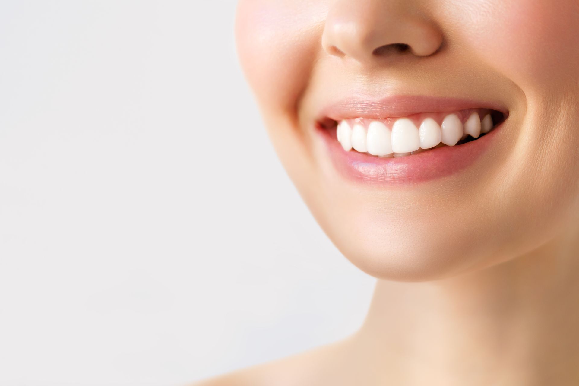 Close-up of a woman smiling with bright, healthy white teeth. Close-up of a woman smiling with bright, healthy white teeth.