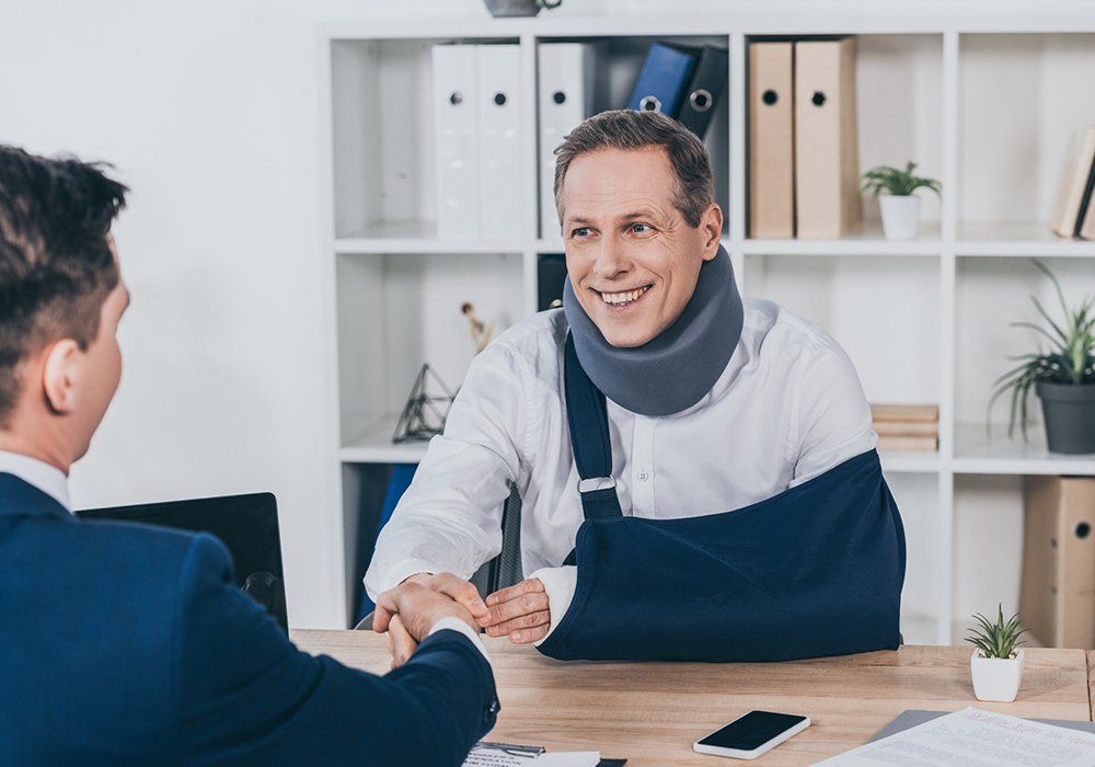 Worker in Neck Brace with Broken Arm and Businessman — Tukwila, WA — Law Offices of Daniel R. Whitmore, P.S. Worker in Neck Brace with Broken Arm and Businessman — Tukwila, WA — Law Offices of Daniel R. Whitmore, P.S.