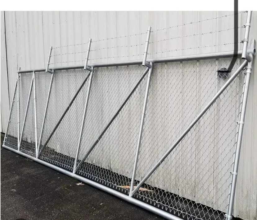 Chain-link fence panels propped against a white wall on a paved surface