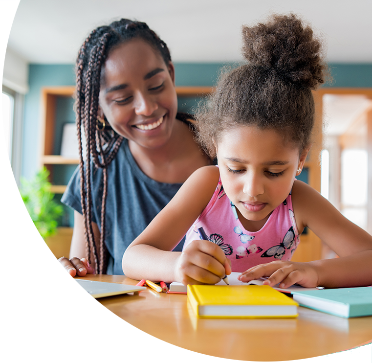 a mom is helping a little girl with her homework