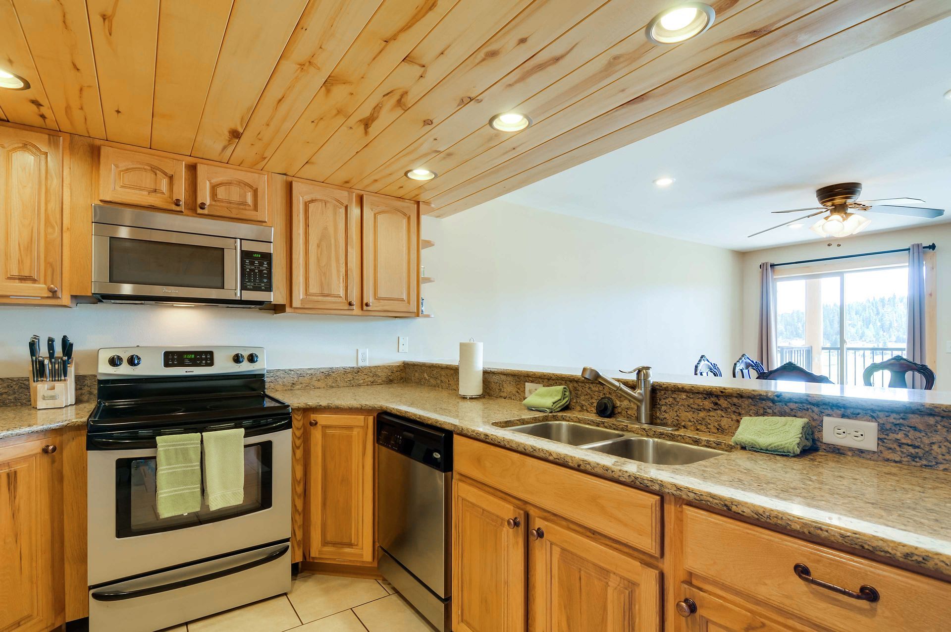 Kitchen with light wood cabinets, granite countertops, and stainless steel appliances. A pass-through.
