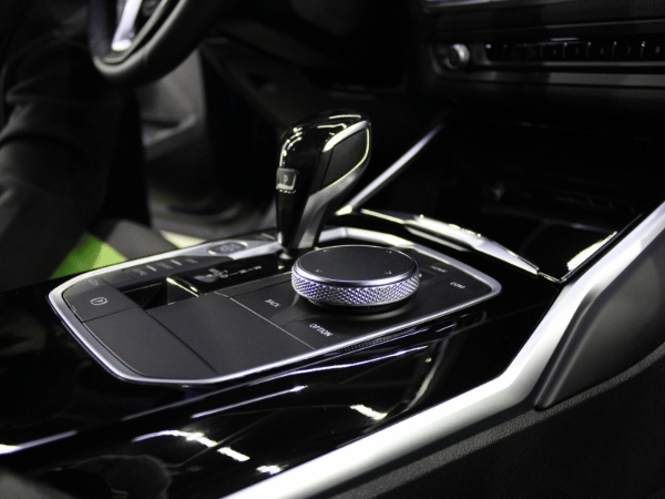 Car center console with glossy black gear selector and rotary control knob