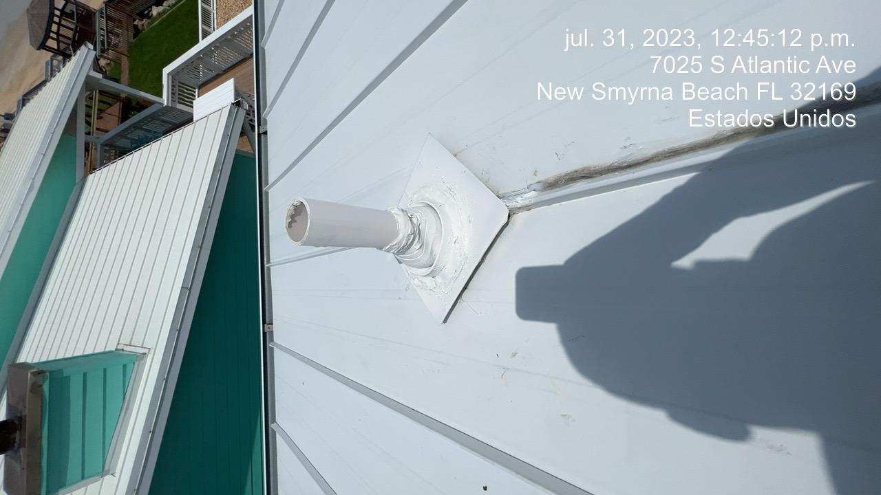 A white pipe protruding from a white roof with the date and address in text overlay.