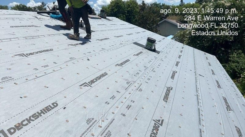 Workers on a roof with DeckShield material, 284 E Warren Ave, Longwood FL, 1:45 PM.