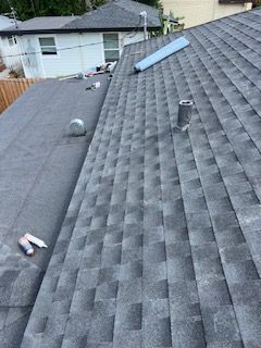 View of a roof with two sections: a shingle roof and a flat roof.