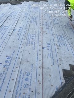 Roofing underlayment installed on a roof, with location data displayed on top.