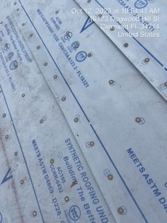 Overhead view of synthetic roofing underlayment with text and fasteners.