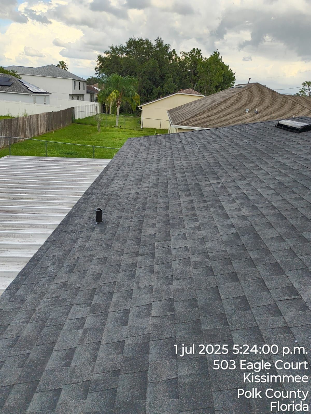 A roof with dark gray shingles and a white flat roof, Kissimmee, Florida.