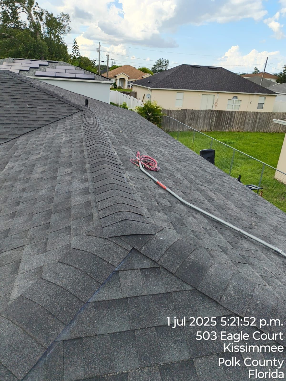 Rooftop view of gray shingles, with a pole extending across. Location: 503 Eagle Court, Kissimmee, Florida.