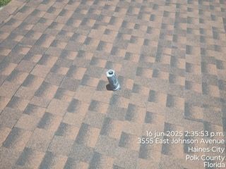 Roof with brown and black shingles and a vent pipe. The photo was taken in Haines City, Florida.