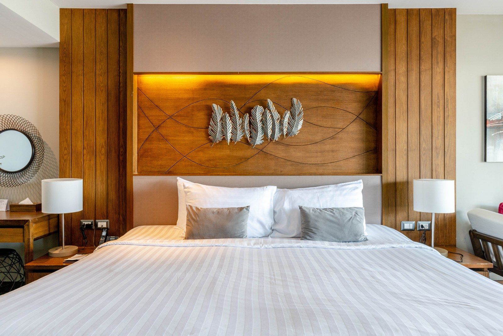 Bedroom with a large bed, wooden headboard, side tables with lamps, and decorative wall art.