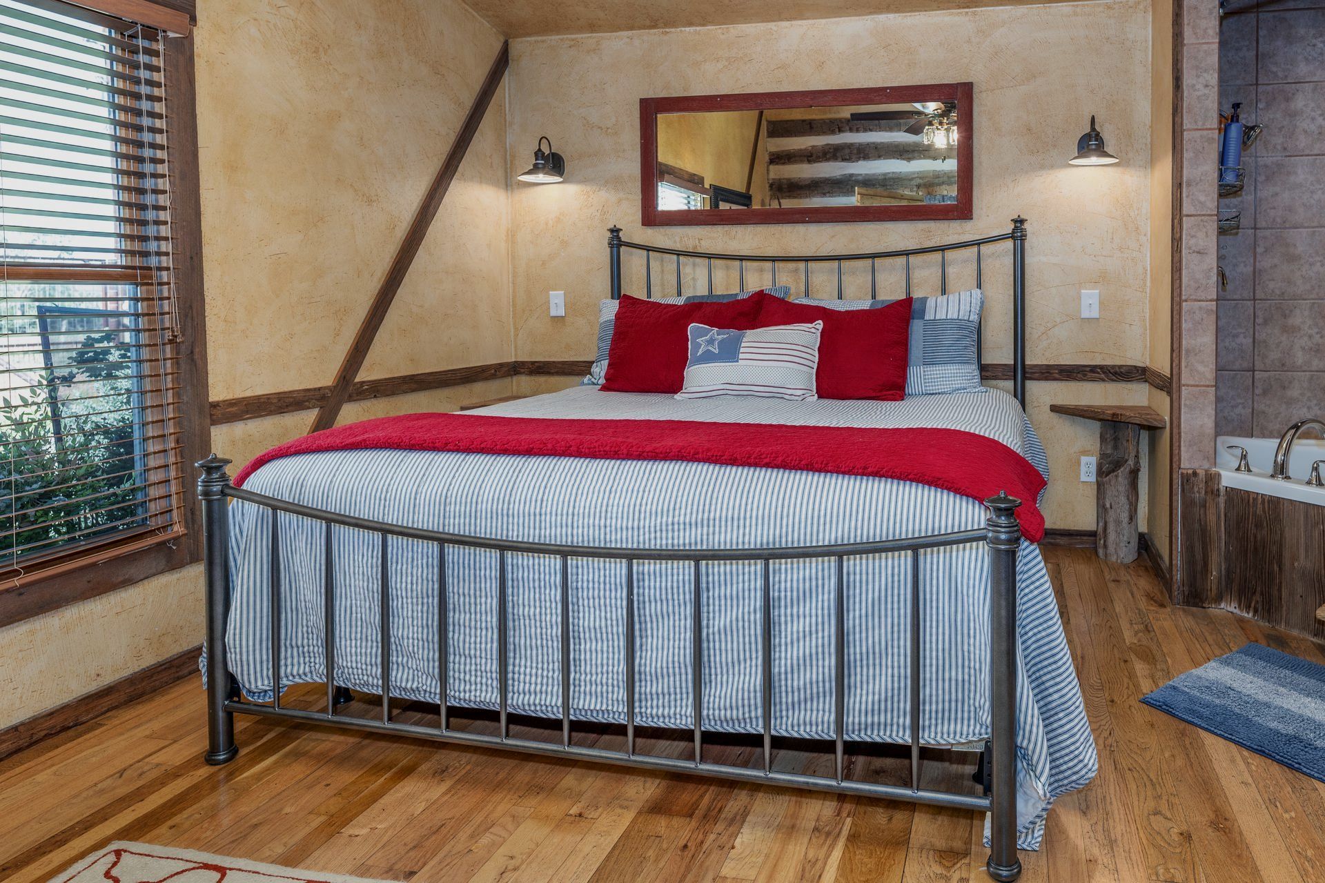 A bedroom with a king size bed and a bathtub.
