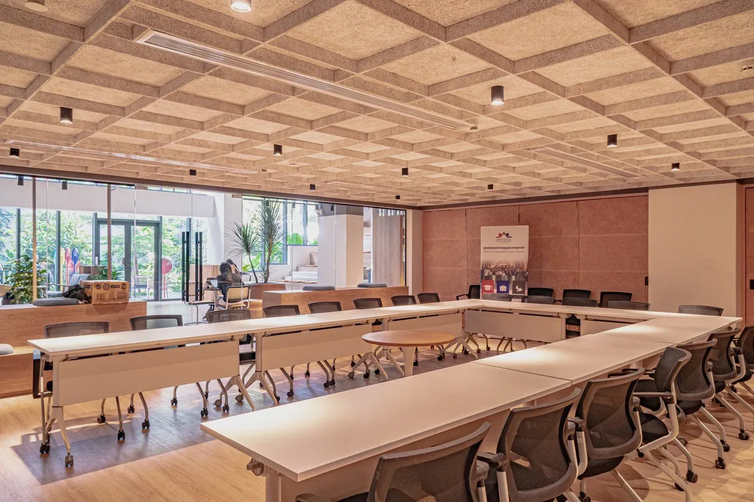 Conference room with U-shaped tables, chairs, and a window.
