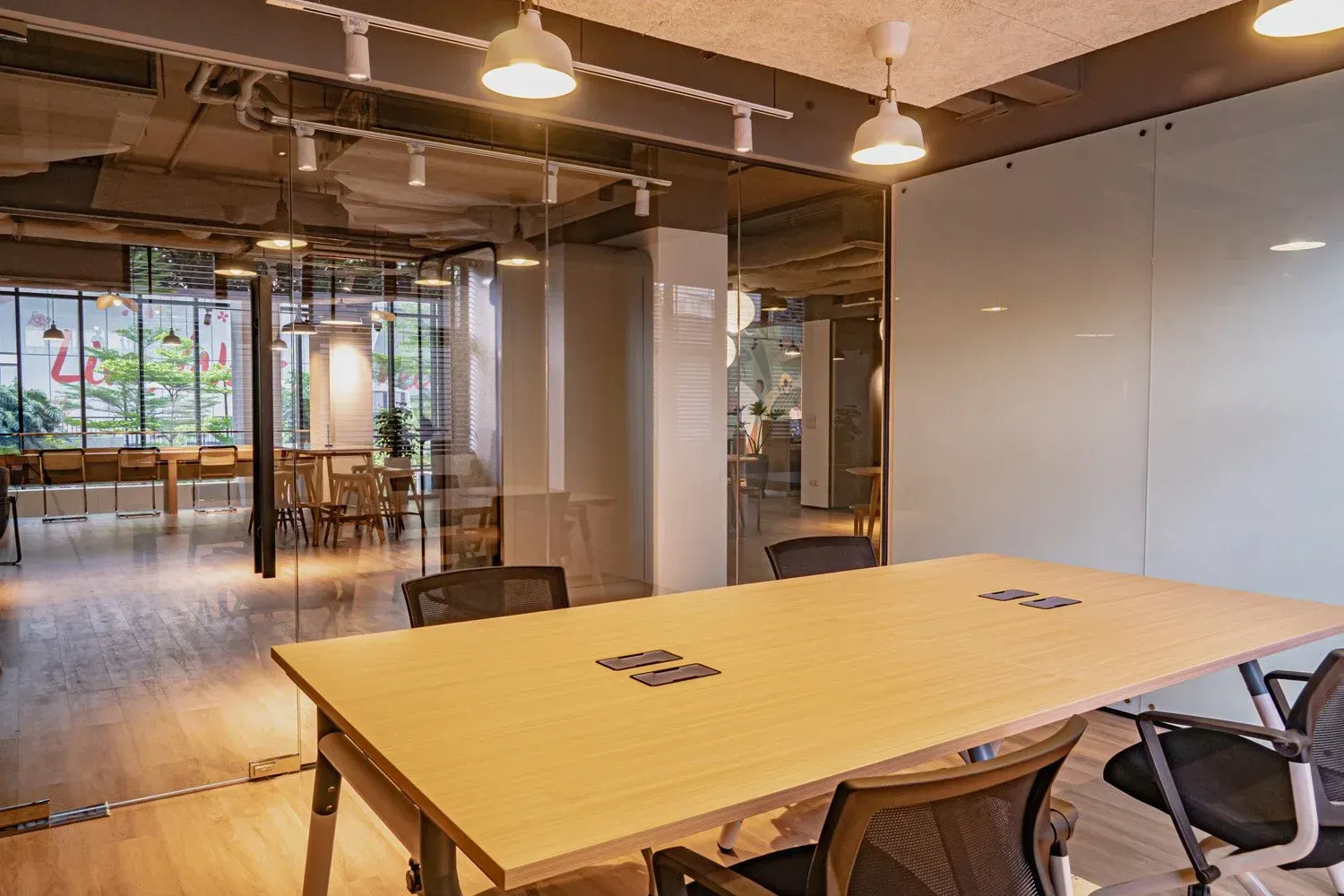 Meeting room with long table and chairs; glass walls.
