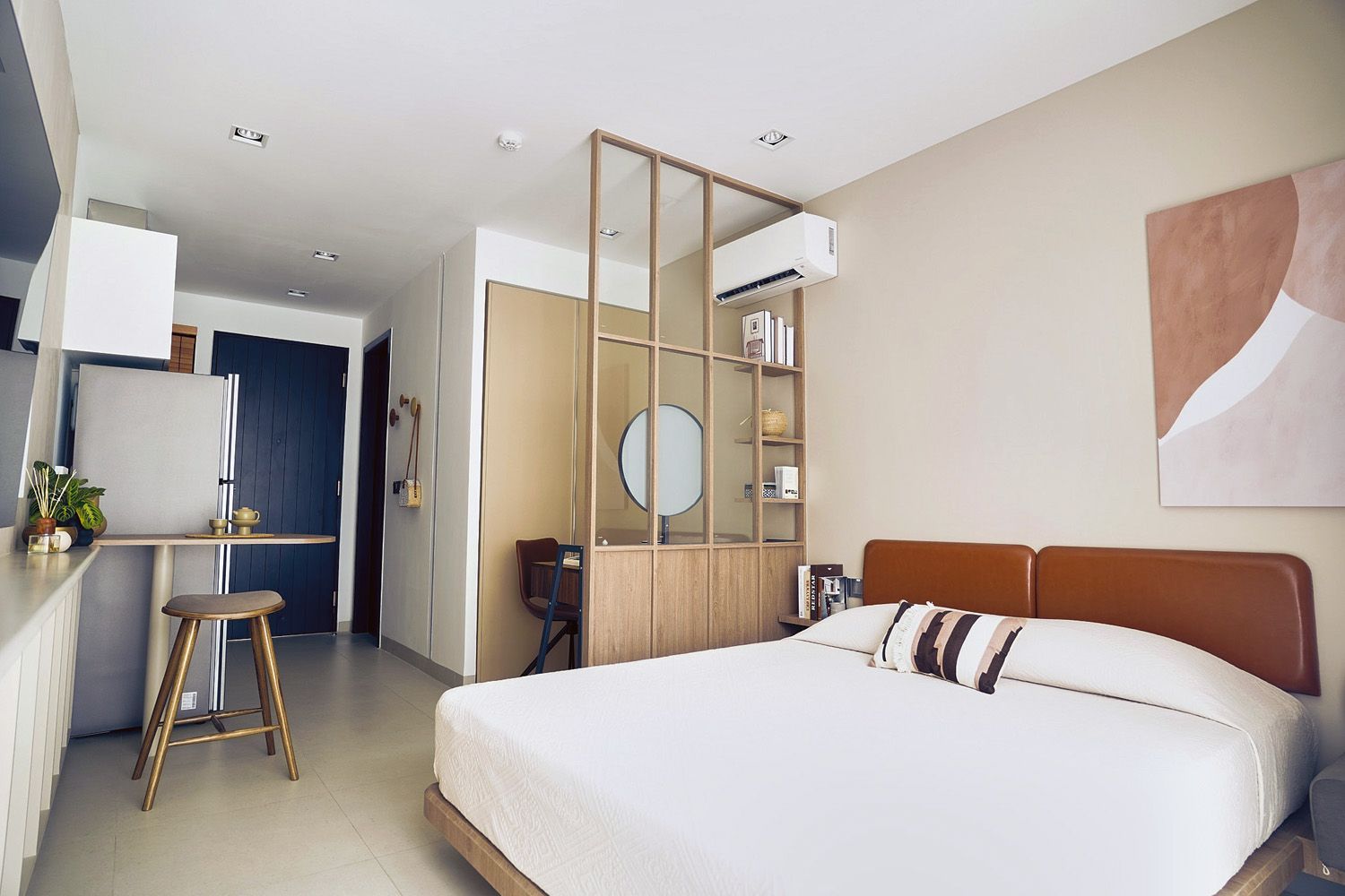 Bedroom with bed, desk, artwork, air conditioner, and wooden room divider.
