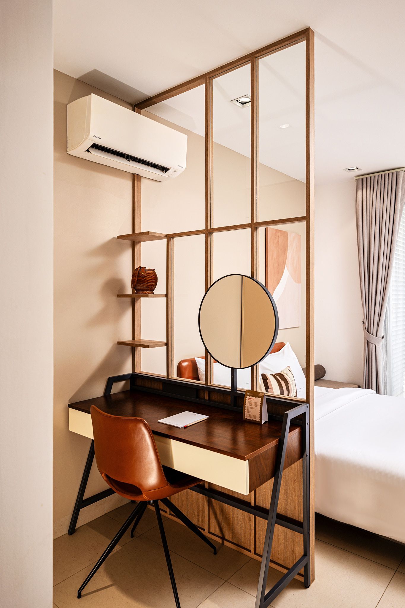 Minimal bedroom desk nook with mirror, chair, and wall-mounted air conditioner