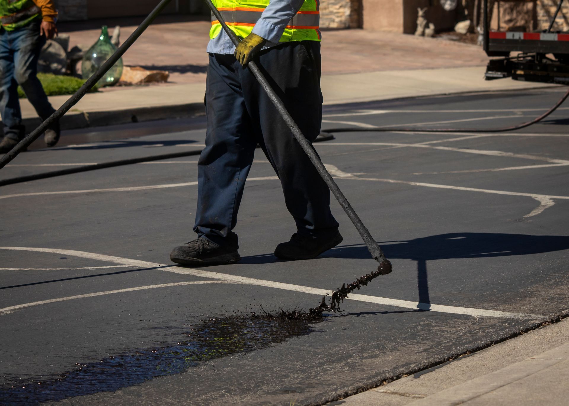 Road workers repairing asphalt with a hot tar machine on a street