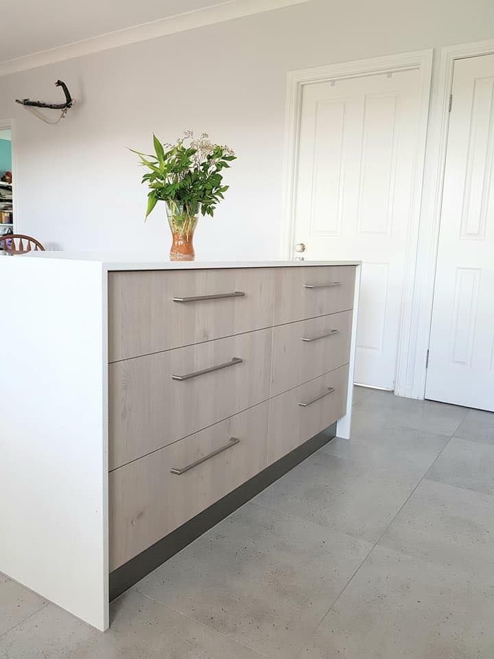 A Dresser With a Vase of Flowers on Top of It in a Kitchen — NGK Constructions In Freshwater, QLD