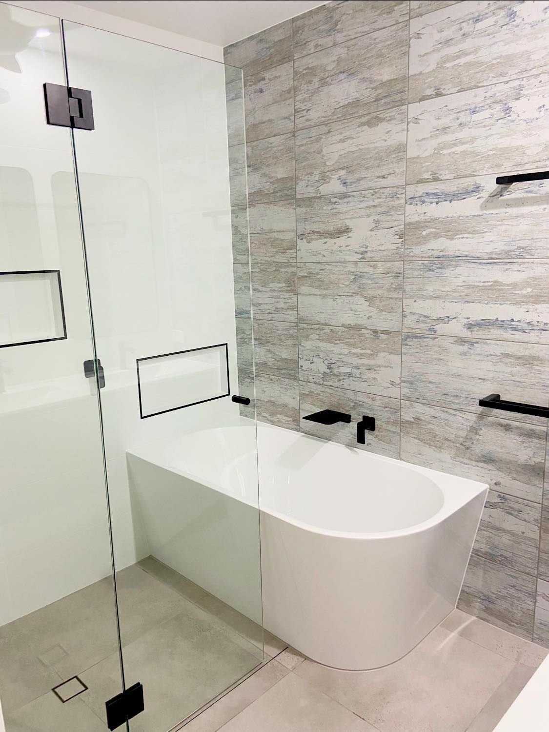 A Bathroom With a Bathtub and a Shower With a Glass Door — NGK Constructions In Freshwater, QLD