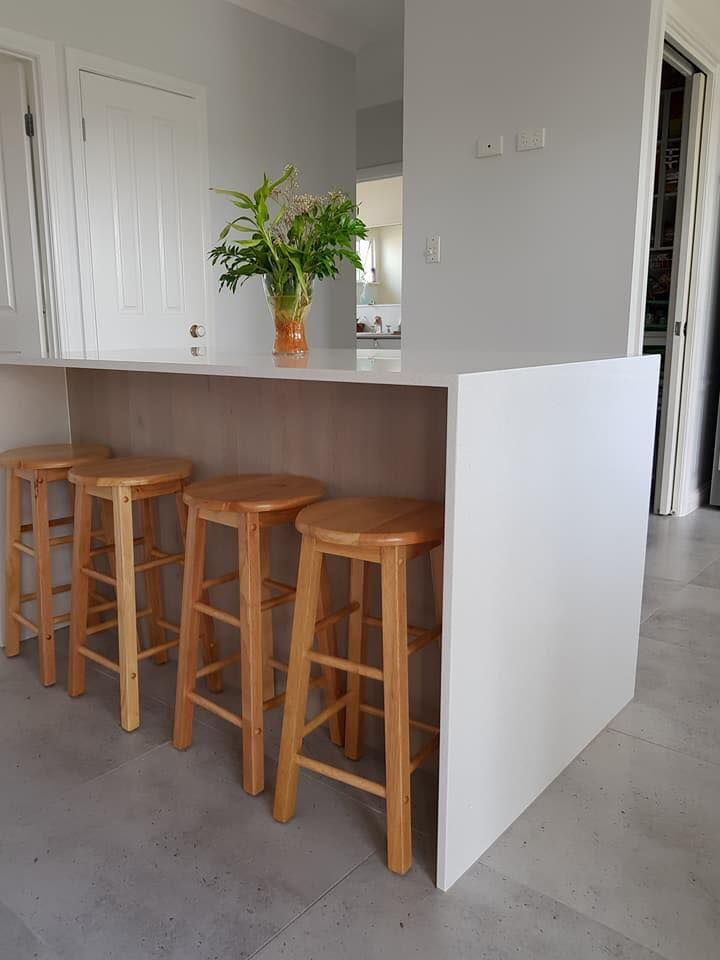 A Kitchen With Wooden Stools and a Plant on the Counter — NGK Constructions In Freshwater, QLD