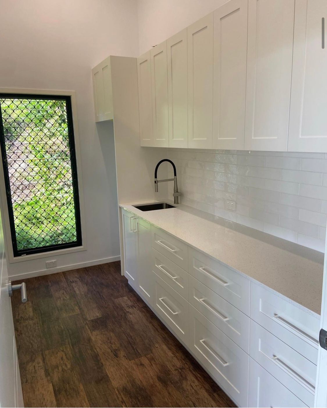 A Kitchen With White Cabinets a Sink, and a Window — NGK Constructions In Freshwater, QLD