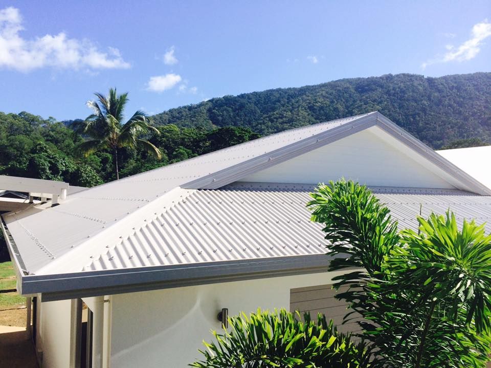 A White House With a White Roof is Surrounded by Trees and Mountains — NGK Constructions In Freshwater, QLD