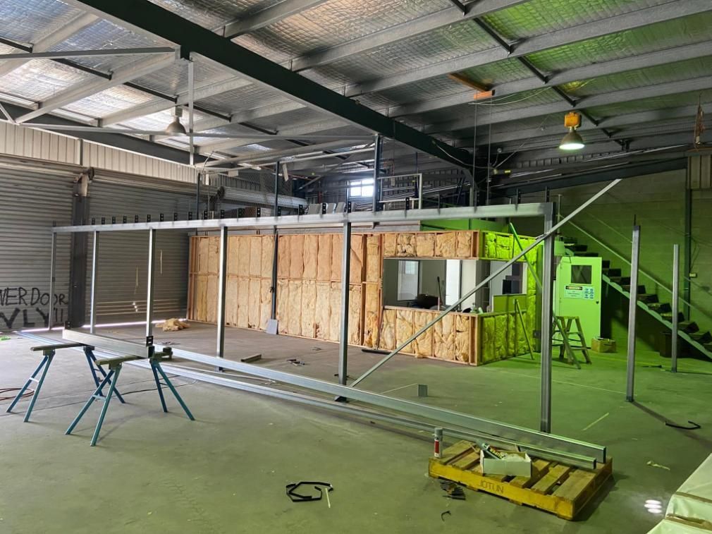 A Large Warehouse With a Green Roof and a Staircase — NGK Constructions In Freshwater, QLD