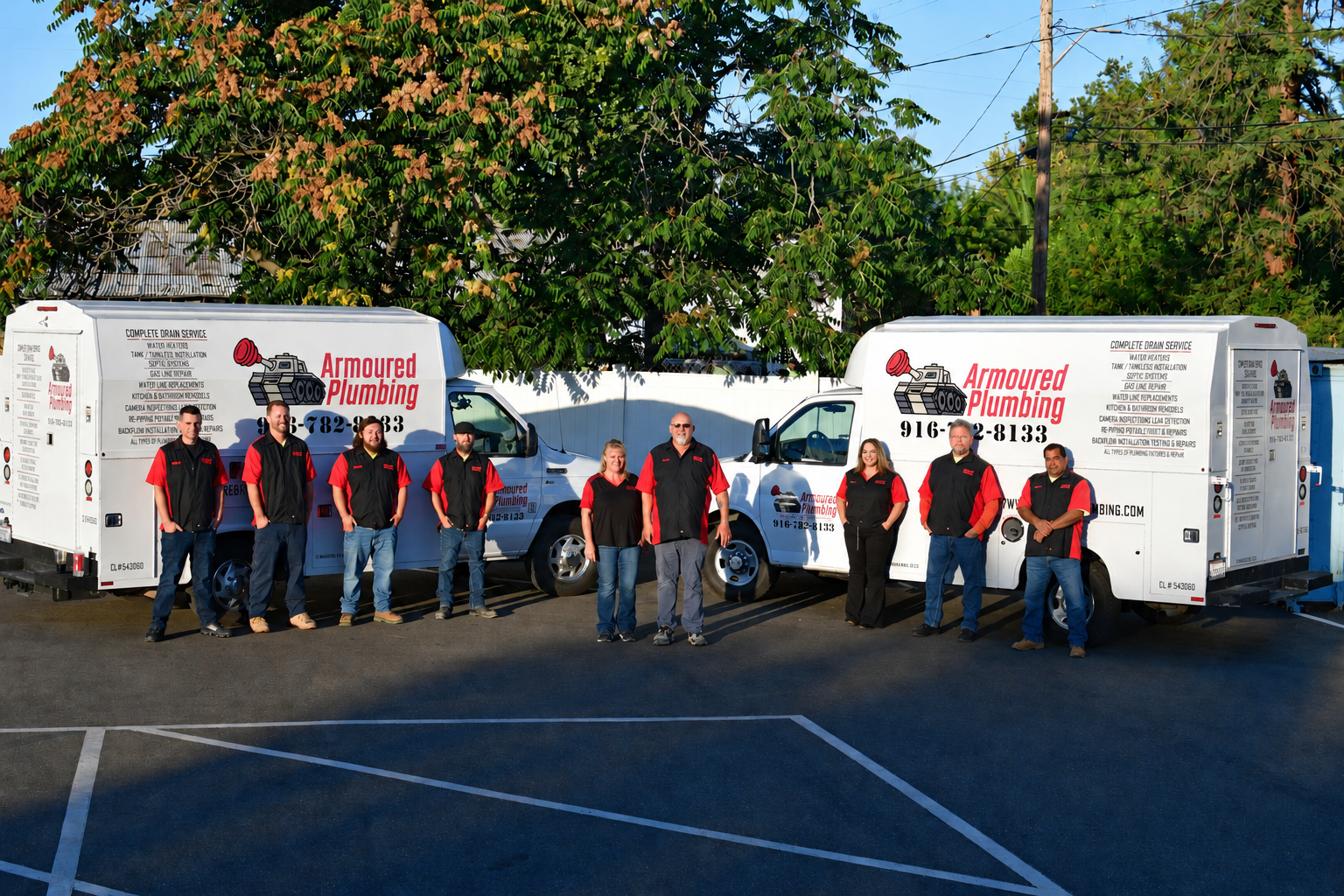 People posing with red-and-white trailers and a white van in a parking lot