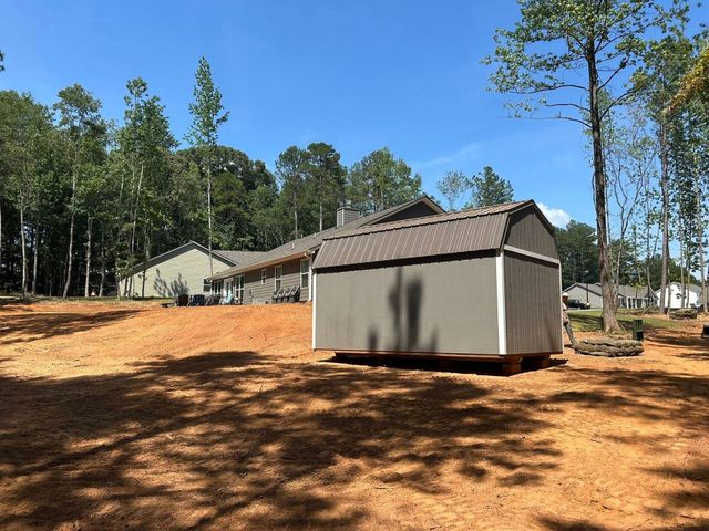 Finished cleared and levelled ground behind a home with a new outbuilding set in place.