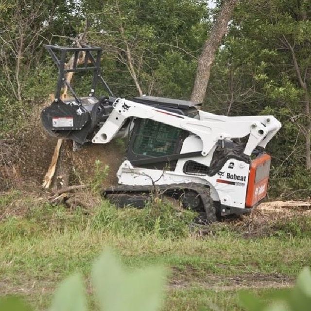 Acres of open ground finished in mulch, photographed from the operator's seat behind the mulching head.