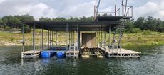 Dock with a covered boat slip, and a second story observation deck, on a lake.