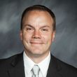 A man in a suit and tie is smiling for the camera